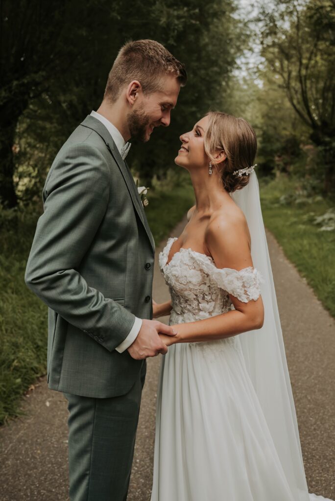 Hochzeitsfotograf Krefeld - Brautpaar posiert im Boho-Stil im Wald, umgeben von natürlichem Licht und sanfter Atmosphäre.