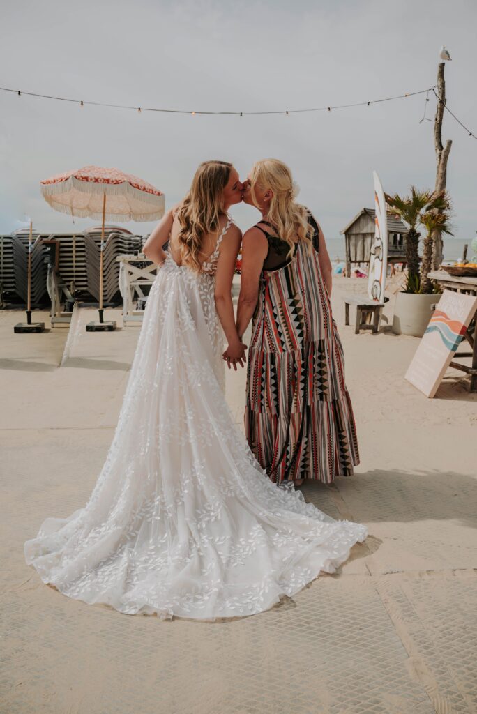 Braut küsst ihre Brautmutter vor der freien Trauung am Strand