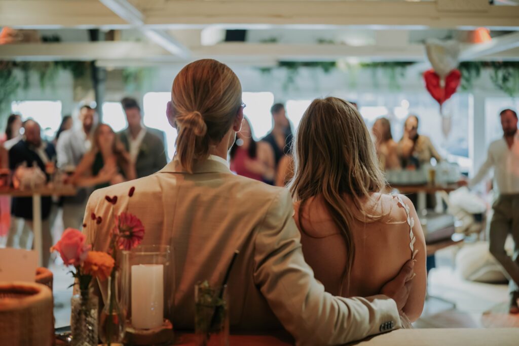 Brautpaar von hinten beim Dinner, warme Abendstimmung und Kerzenlicht