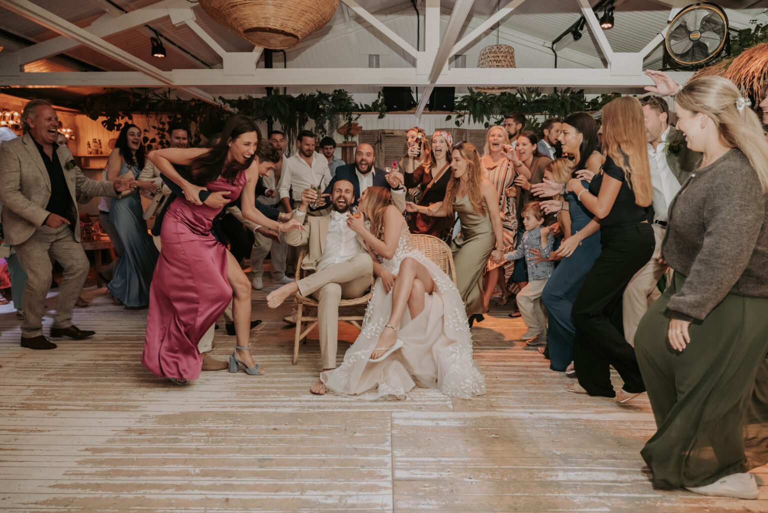 Gäste stürmen jubelnd auf das Brautpaar zu, ausgelassene Party-Stimmung
