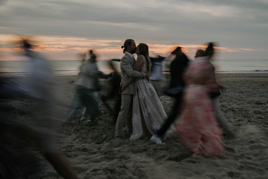 Kuss in der Golden Hour am Strand in Castricum, Gäste verschwommen durch Langzeitbelichtung