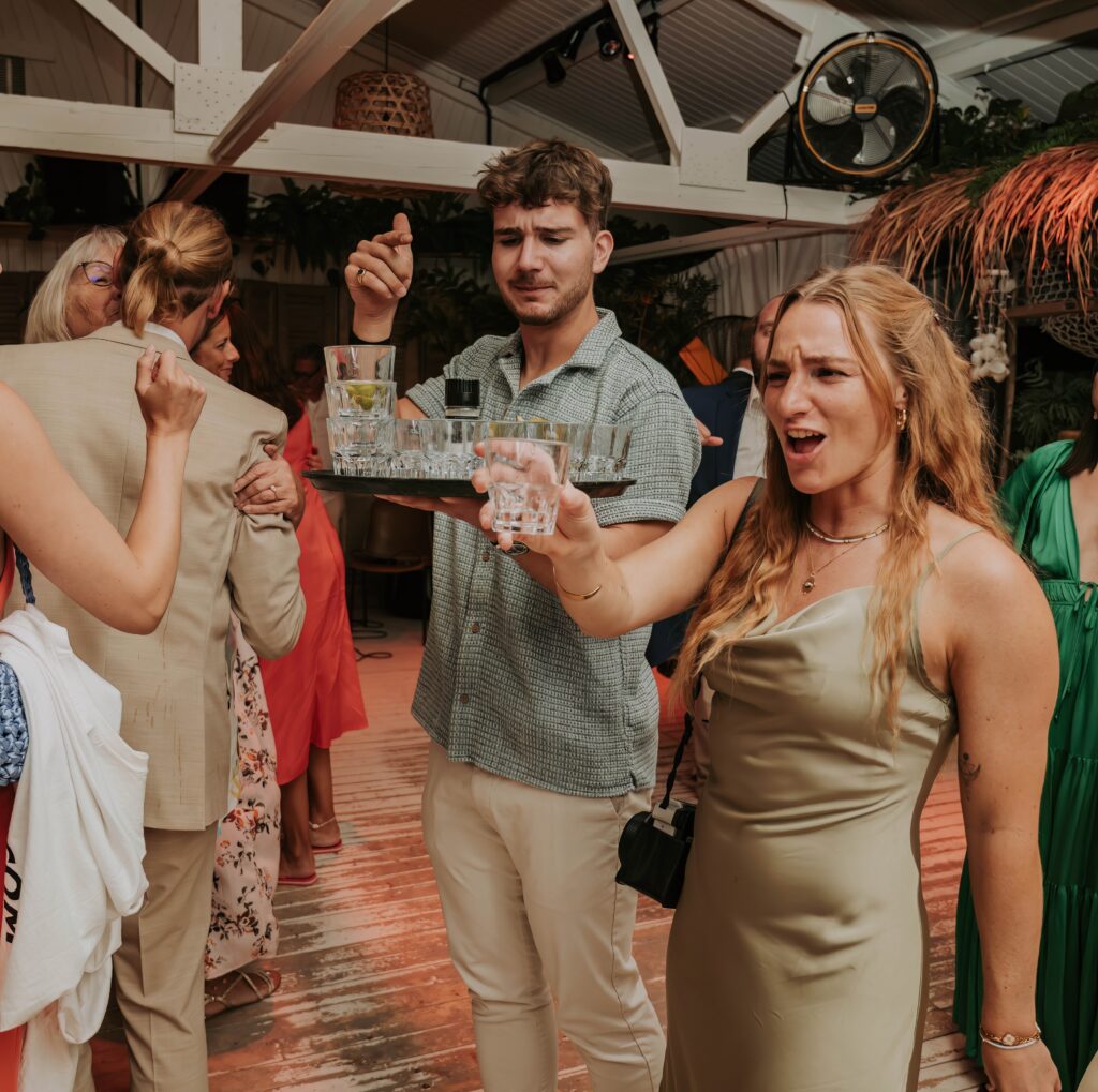 Freunde stürmen jubelnd auf das Brautpaar zu – dynamischer Moment