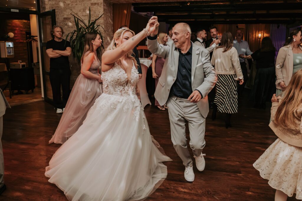 Braut tanzt mit einem Gast bei der Hochzeitsparty in Essen