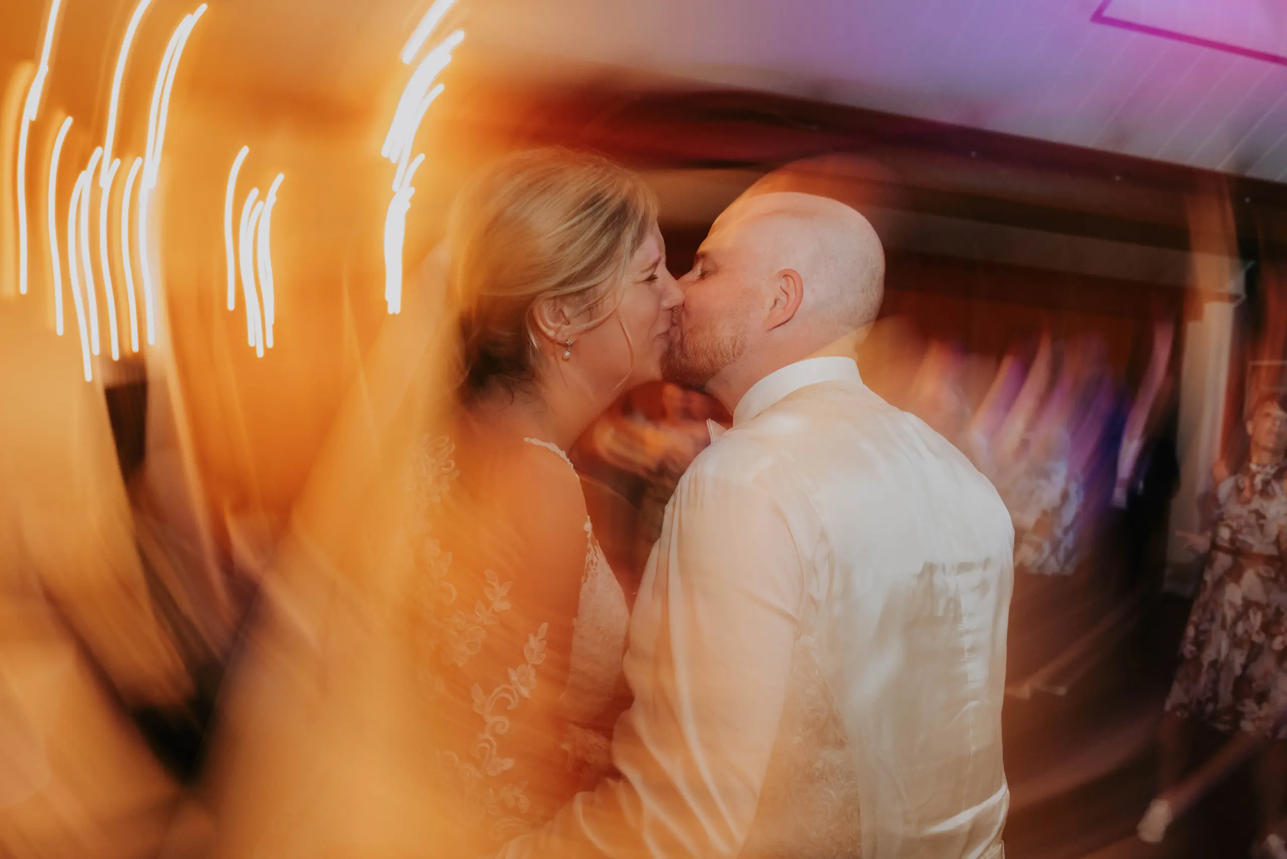 Marina und Dennis küssen sich während der ausgelassenen Hochzeitsparty