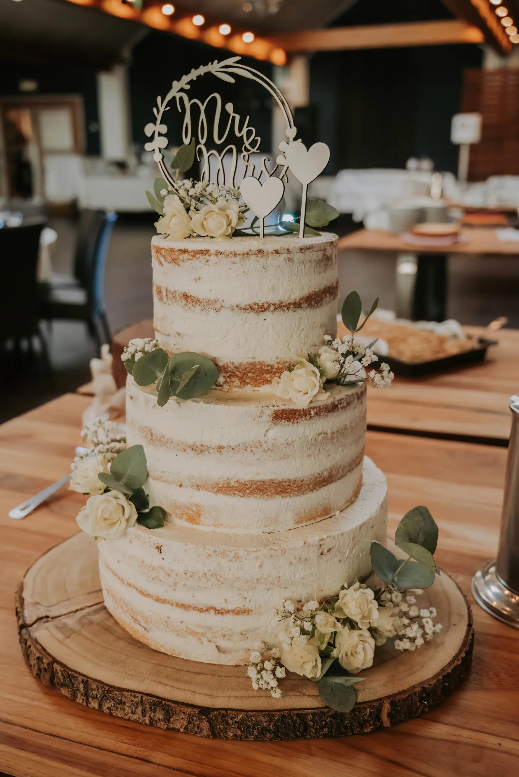Dreistöckige Hochzeitstorte mit weißen Blumen und Eukalyptus