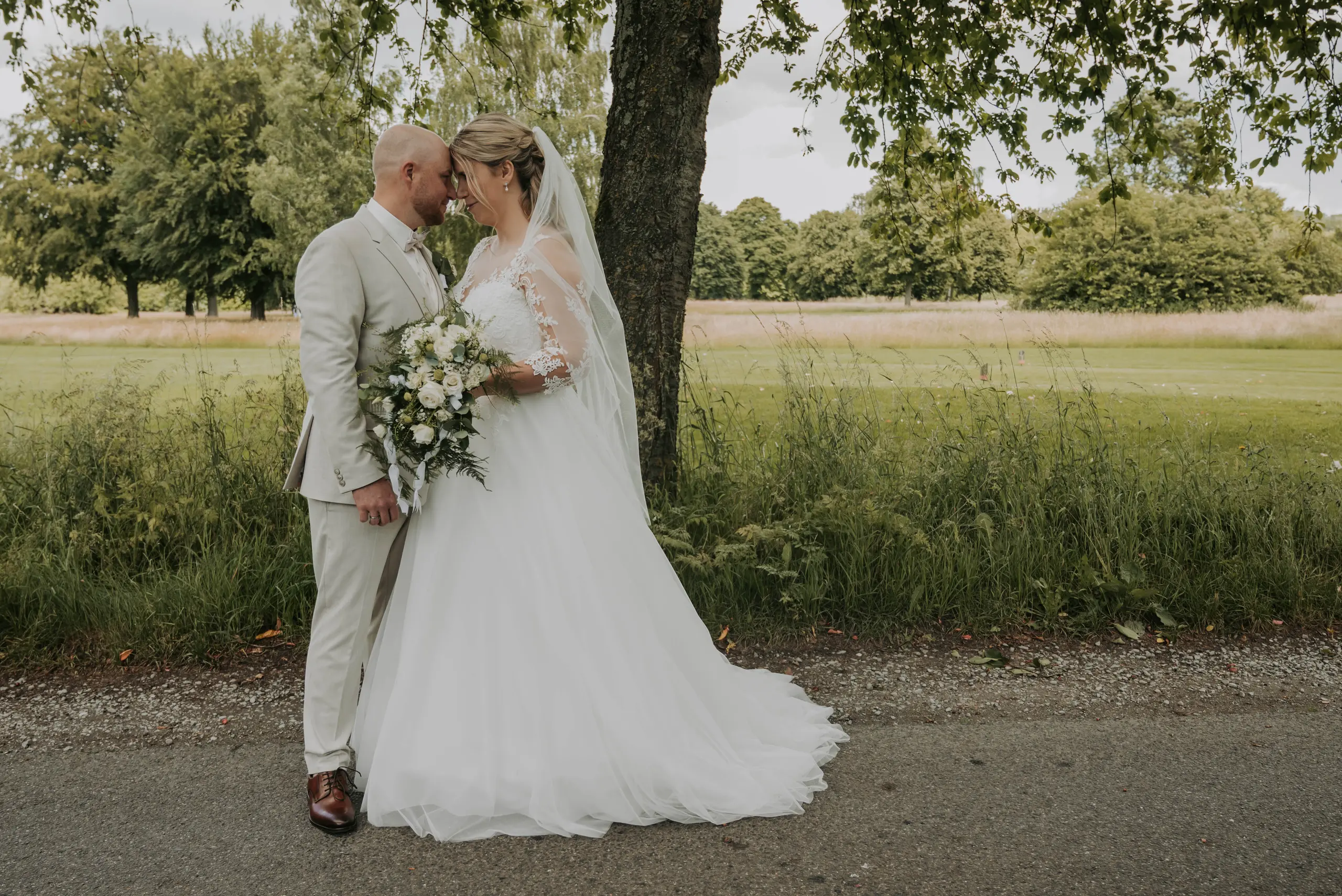 Marina und Dennis stehen bei ihrem Paarshooting unter einem Baum