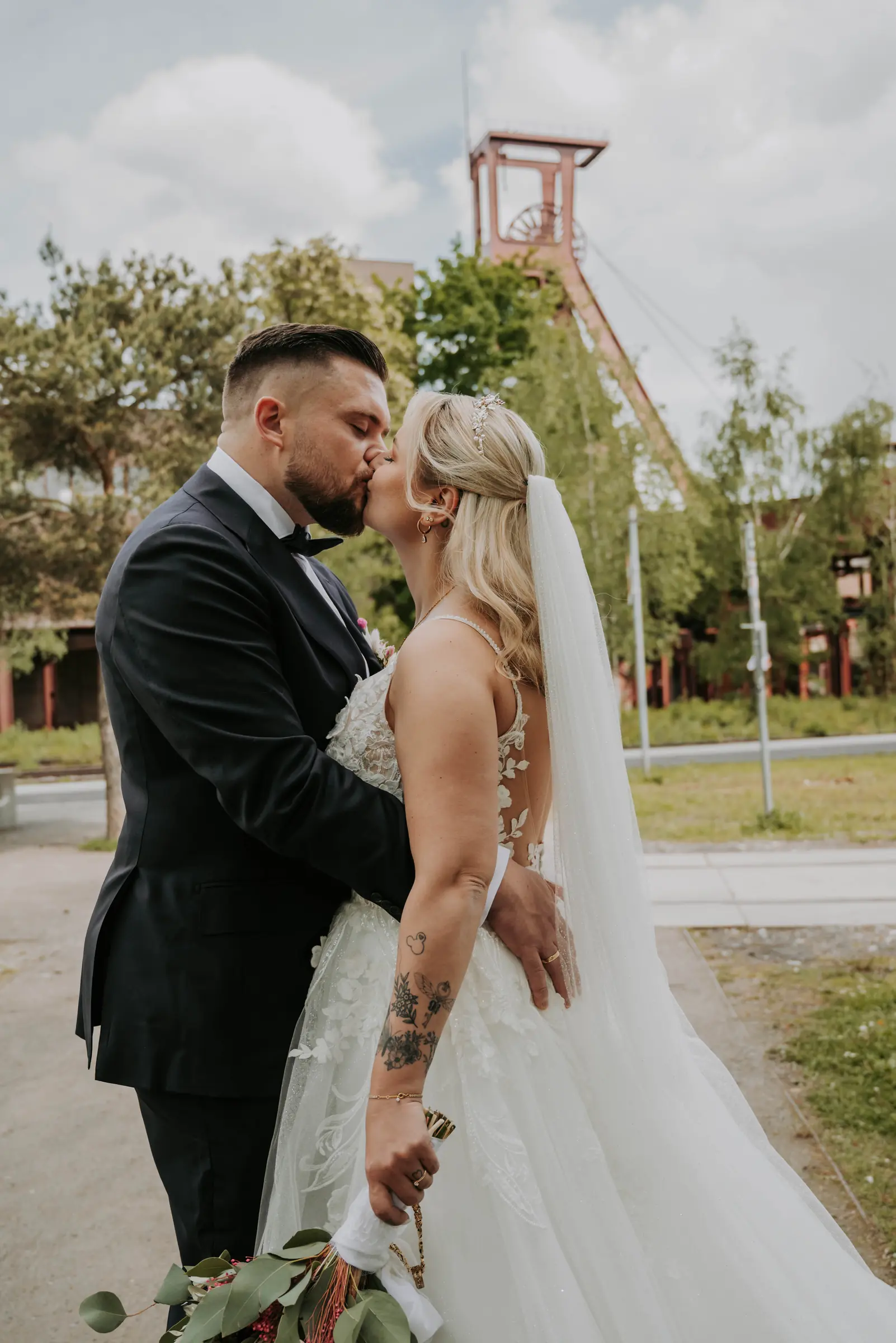 Laura und David küssen sich beim Paarshooting auf Zollverein in Essen.